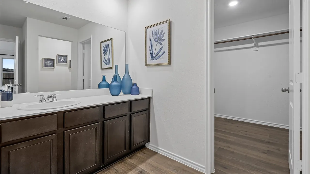 Vanity with a white countertop and integrated sink, complemented by dark wood-finish cabinetry