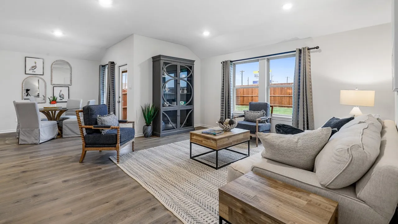 Spacious living area featuring wood-finish flooring, recessed lighting, and large windows