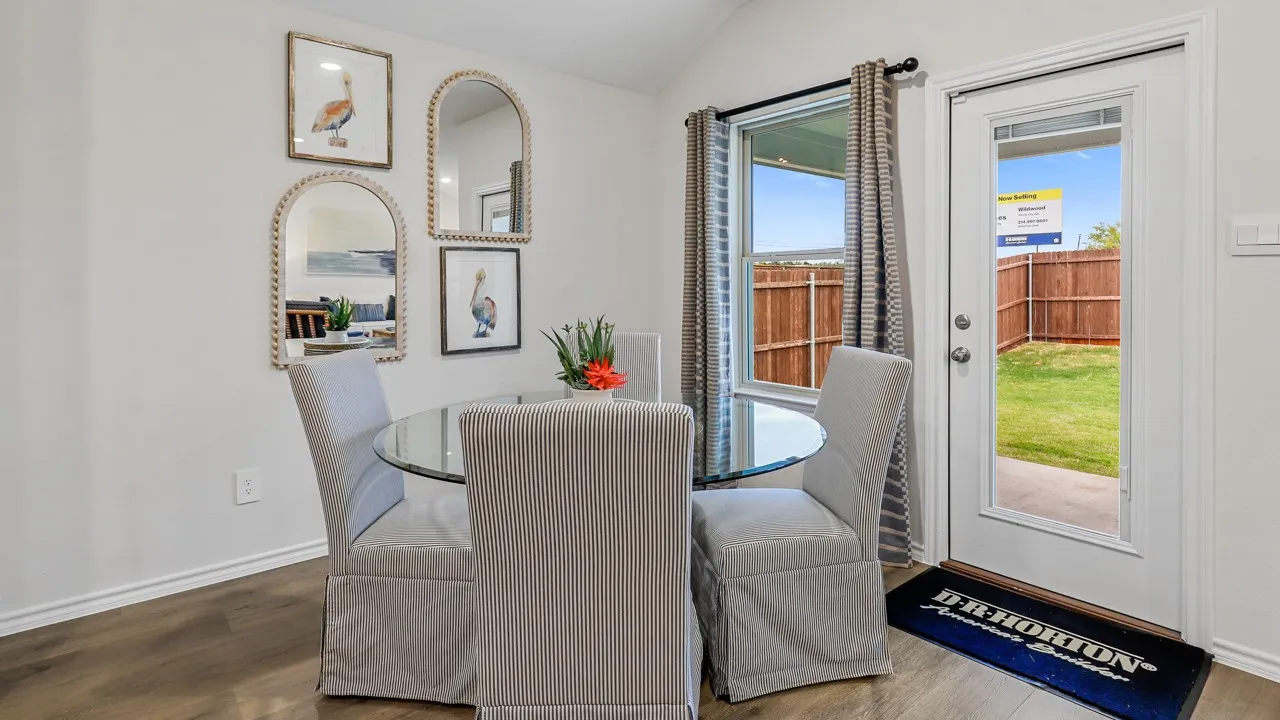 Dining area featuring wood-finish flooring, a full-lite exterior door, and an exterior window with horizontal blinds