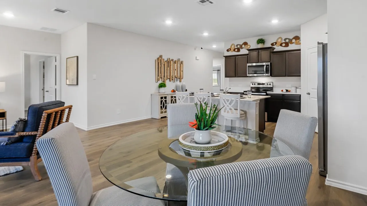 Open-concept living space featuring wood-finish flooring, recessed lighting, and a kitchen with dark cabinetry and stainless steel appliances