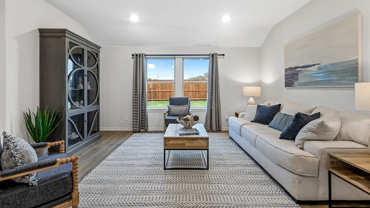 Living area featuring wood-finish flooring, vaulted ceilings, and a large window