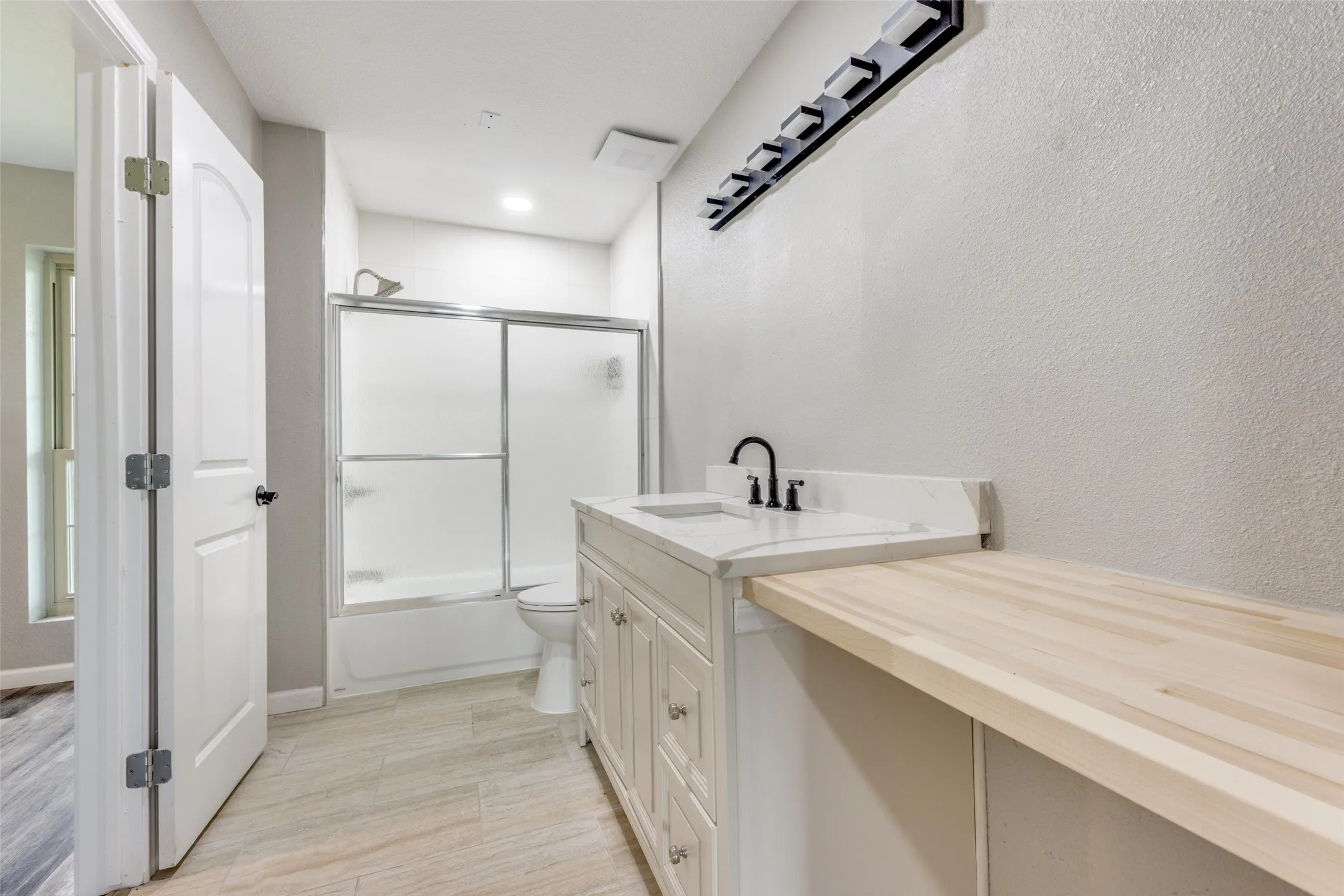 Full bathroom featuring enclosed tub / shower combo and vanity