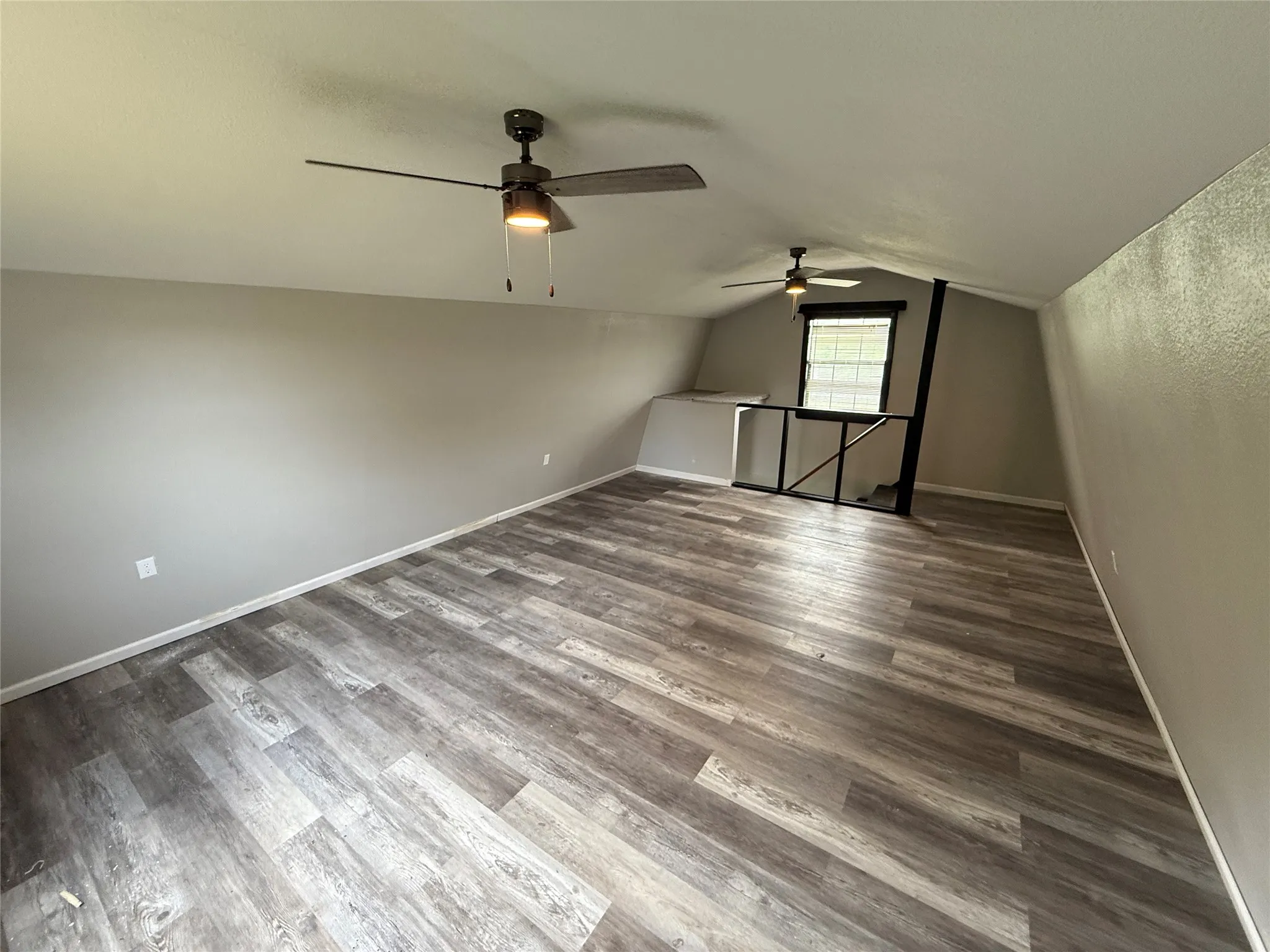 Additional living space with ceiling fan, dark wood finished floors, and vaulted ceiling