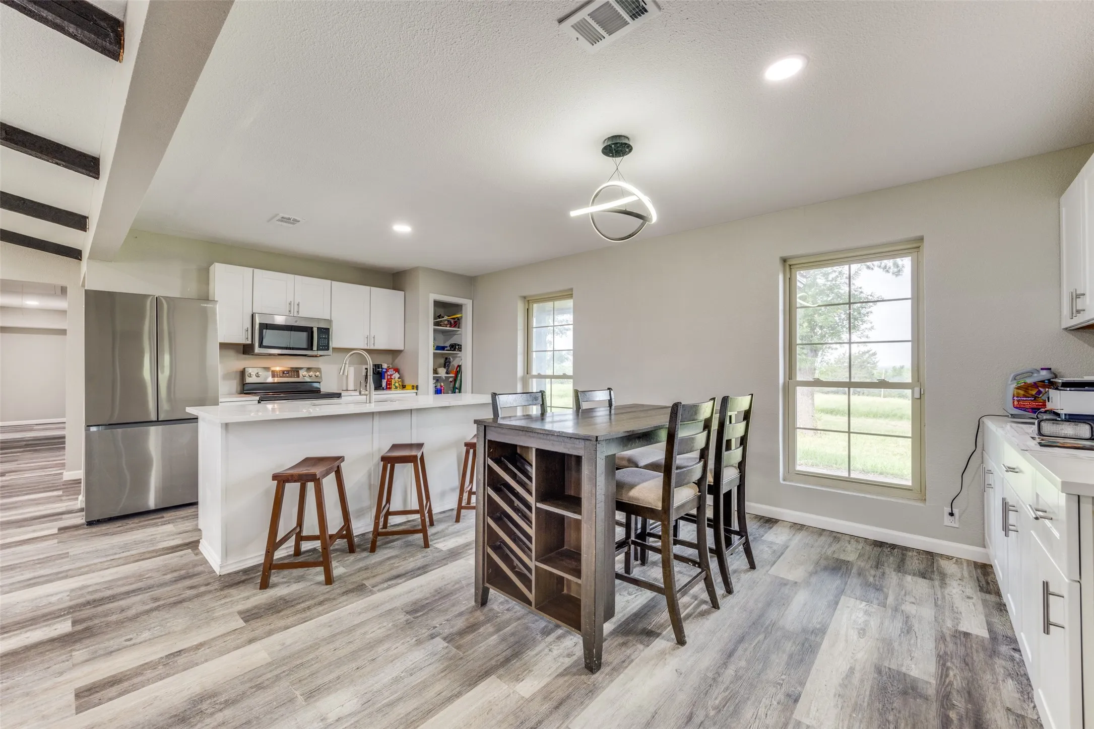 Dining area with light wood finished floors and recessed lighting