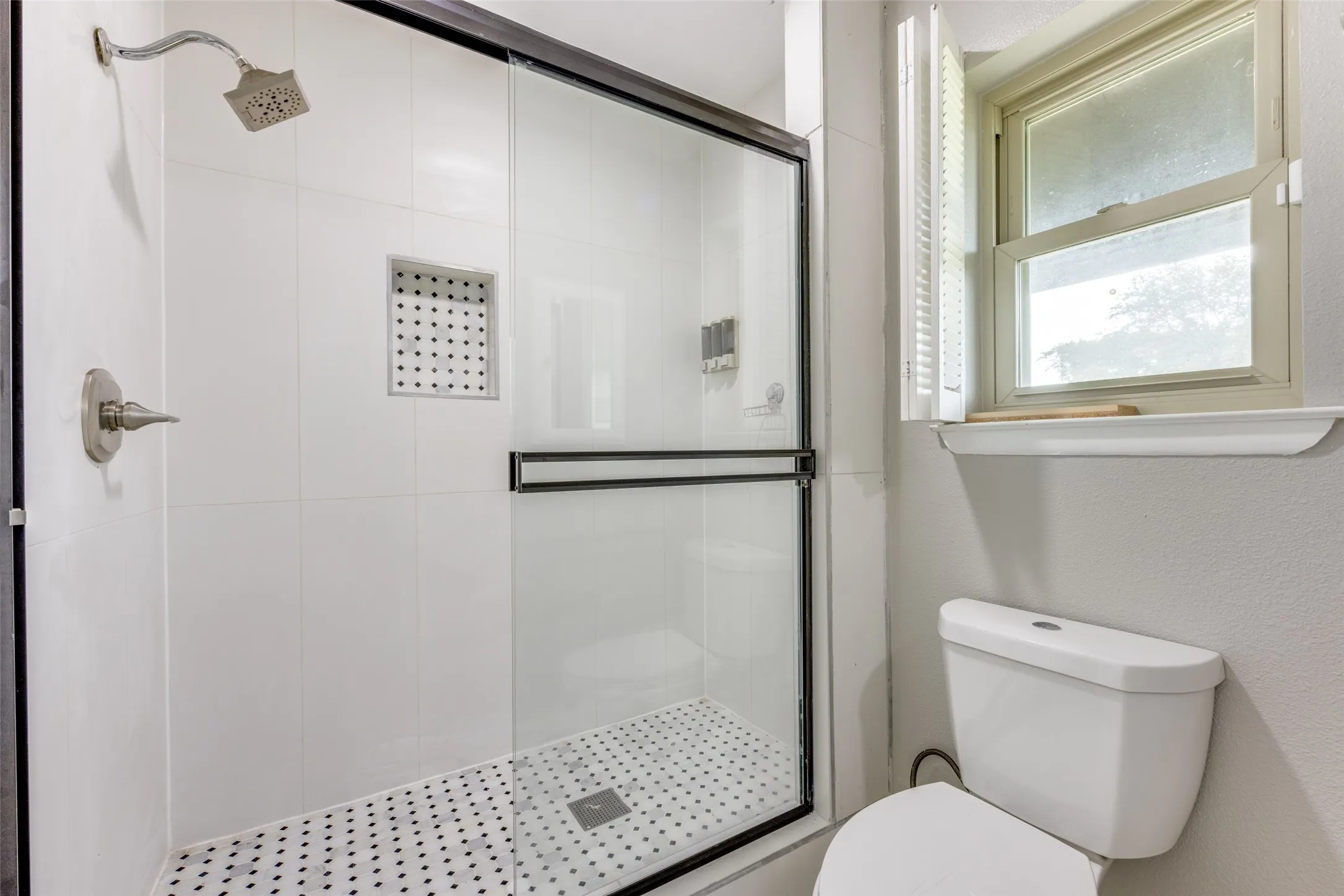 Full bathroom featuring a shower stall and toilet