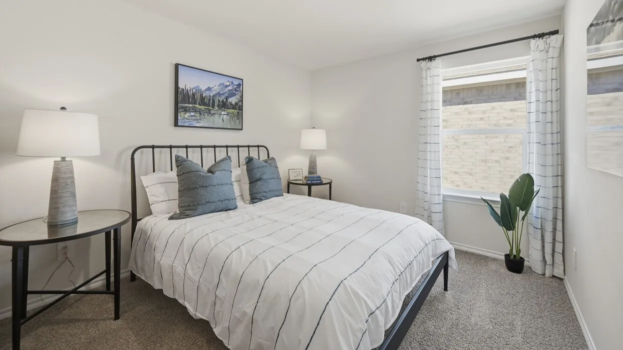 Bedroom featuring light neutral wall paint, carpet flooring, a window with curtains, and a metal bed frame