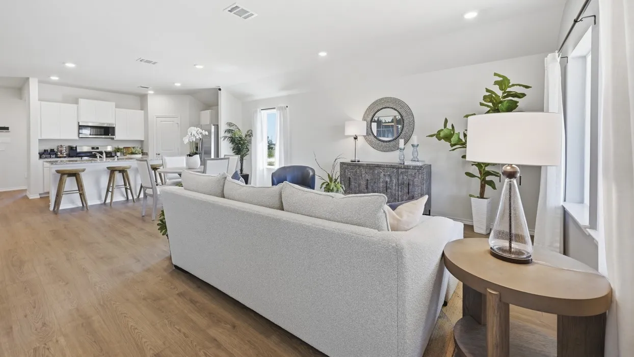 Open-concept living space featuring wood-finish flooring, recessed lighting, and ample natural light from multiple windows