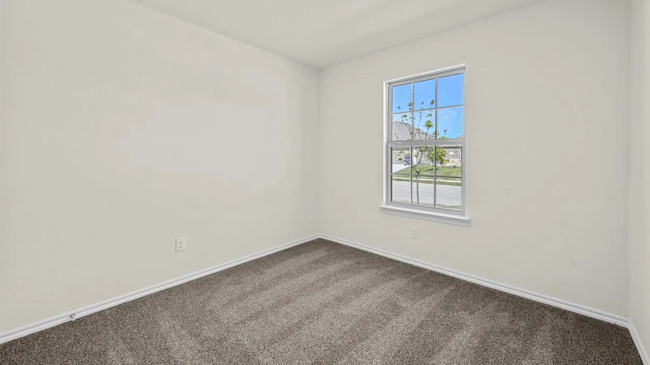 Room featuring textured light-colored walls, patterned carpet flooring, and white baseboards