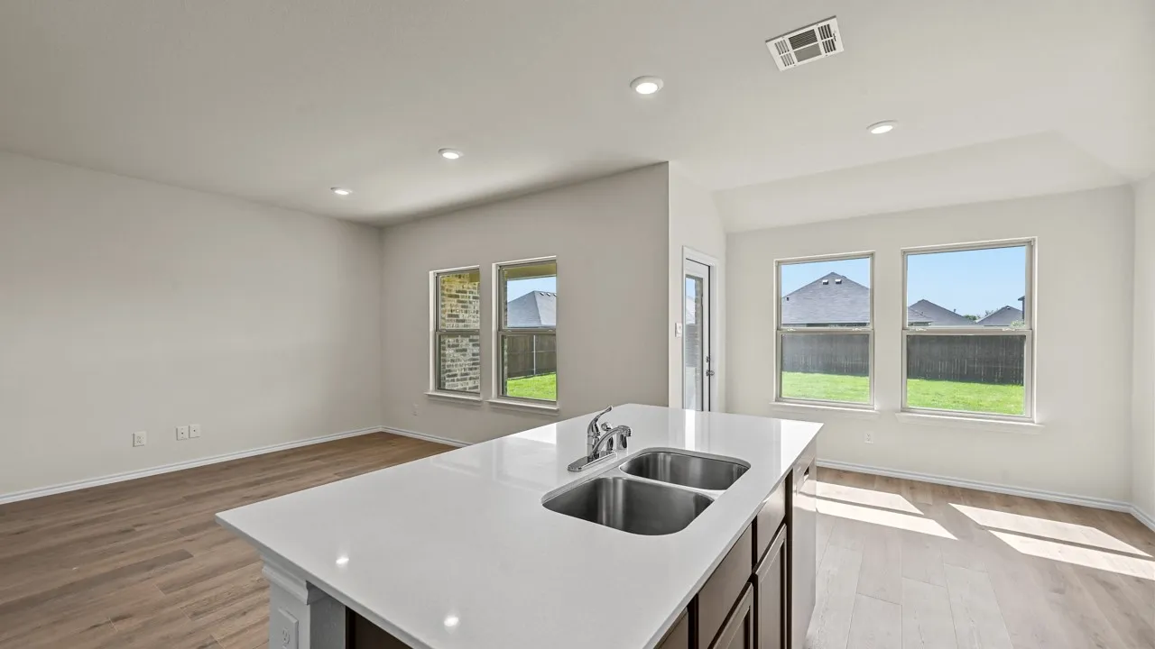 Kitchen island featuring a double basin stainless steel sink with a chrome faucet, set into a light-toned countertop