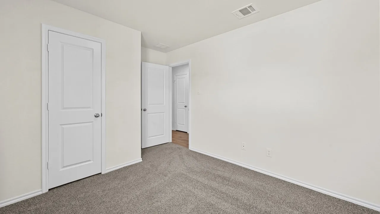 Neutral tone wall paint, gray carpeting, white trim, and white panel doors