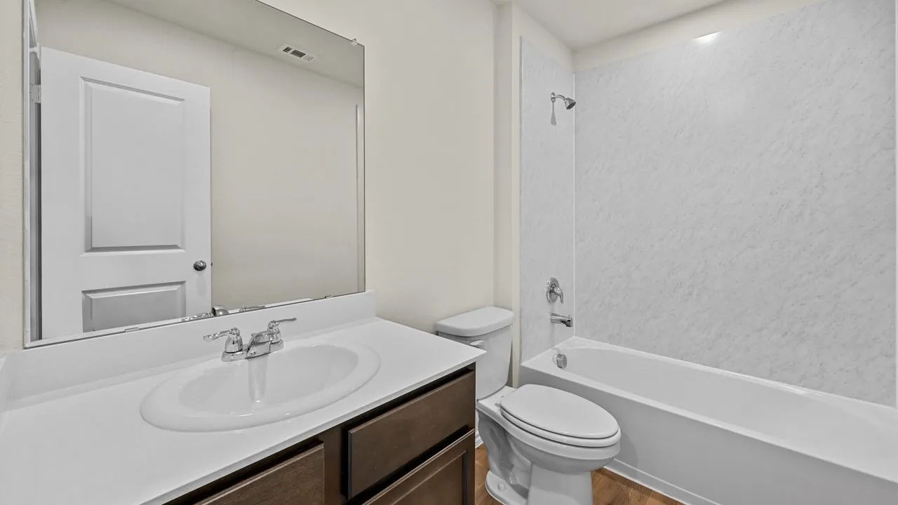 Bathroom featuring a built-in vanity with an integrated sink, polished chrome faucet, and a large mirror