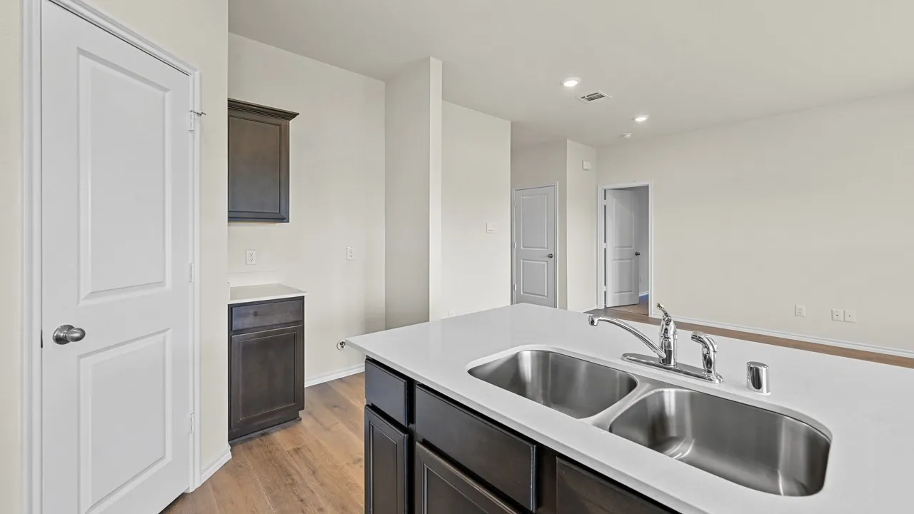 Kitchen island featuring a dual stainless steel sink and a chrome faucet