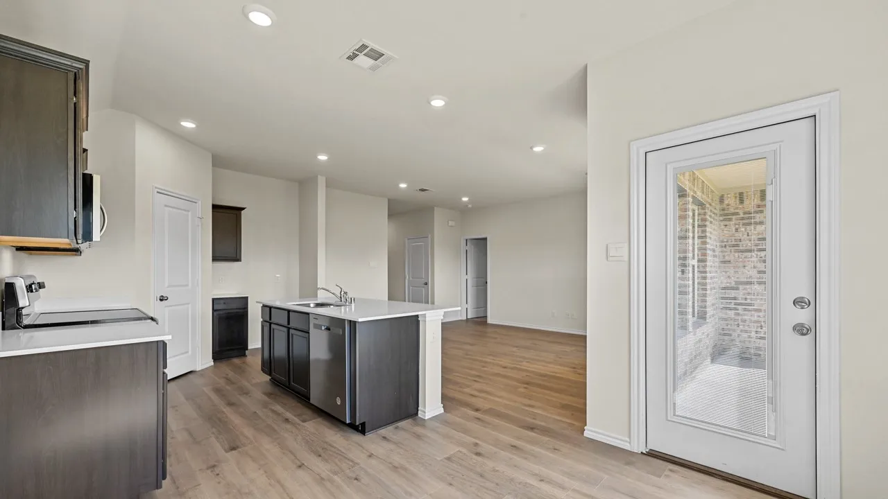 Kitchen with dark wood-finish cabinetry and light-toned countertops
