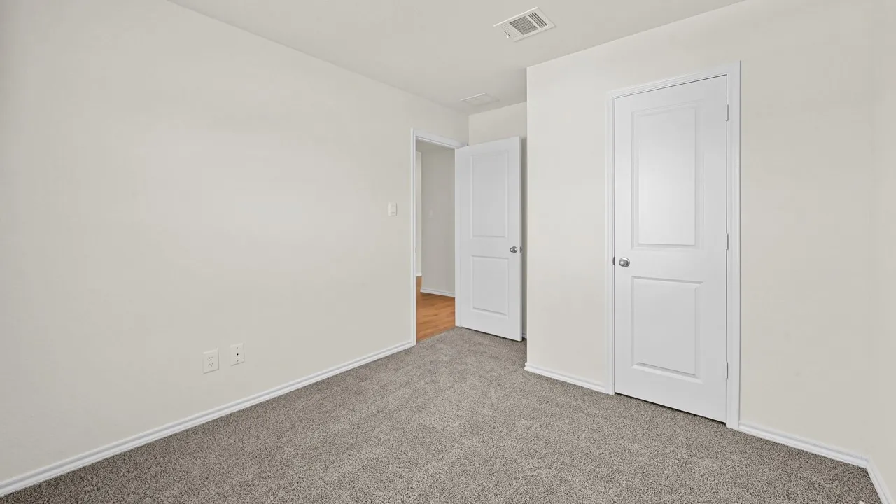 Neutral tone wall finish with a textured gray carpet floor