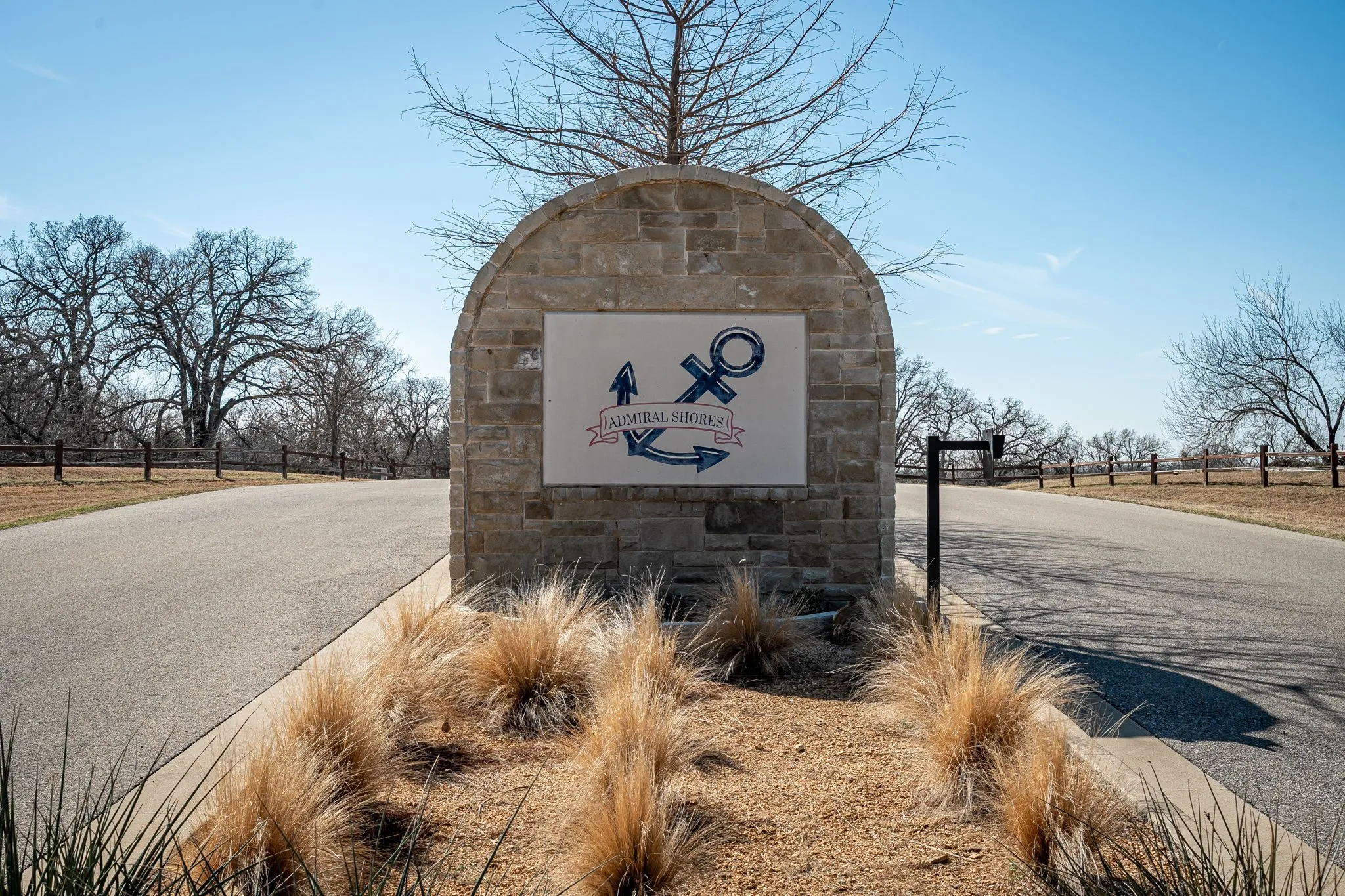 VNeighborhood Monument Sign – Stone monument signage marks the entry into Admiral Shores, a lakeside community with private marina and park access.