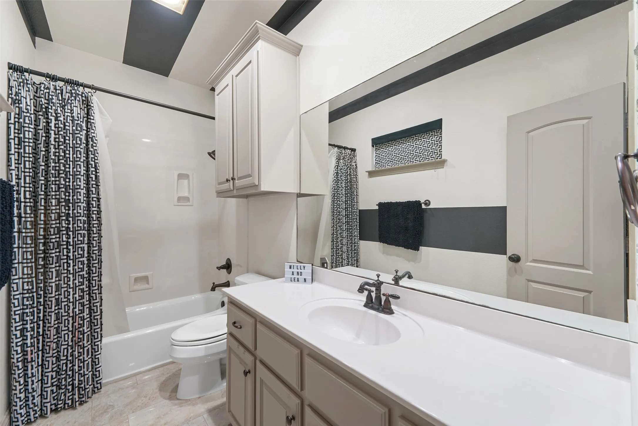Full bathroom featuring vanity and shower / bath combo with shower curtain