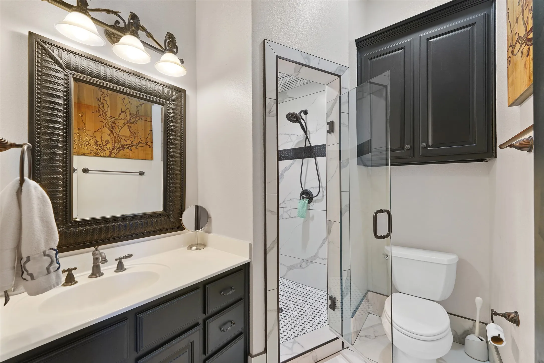 Bathroom featuring a marble finish shower and vanity