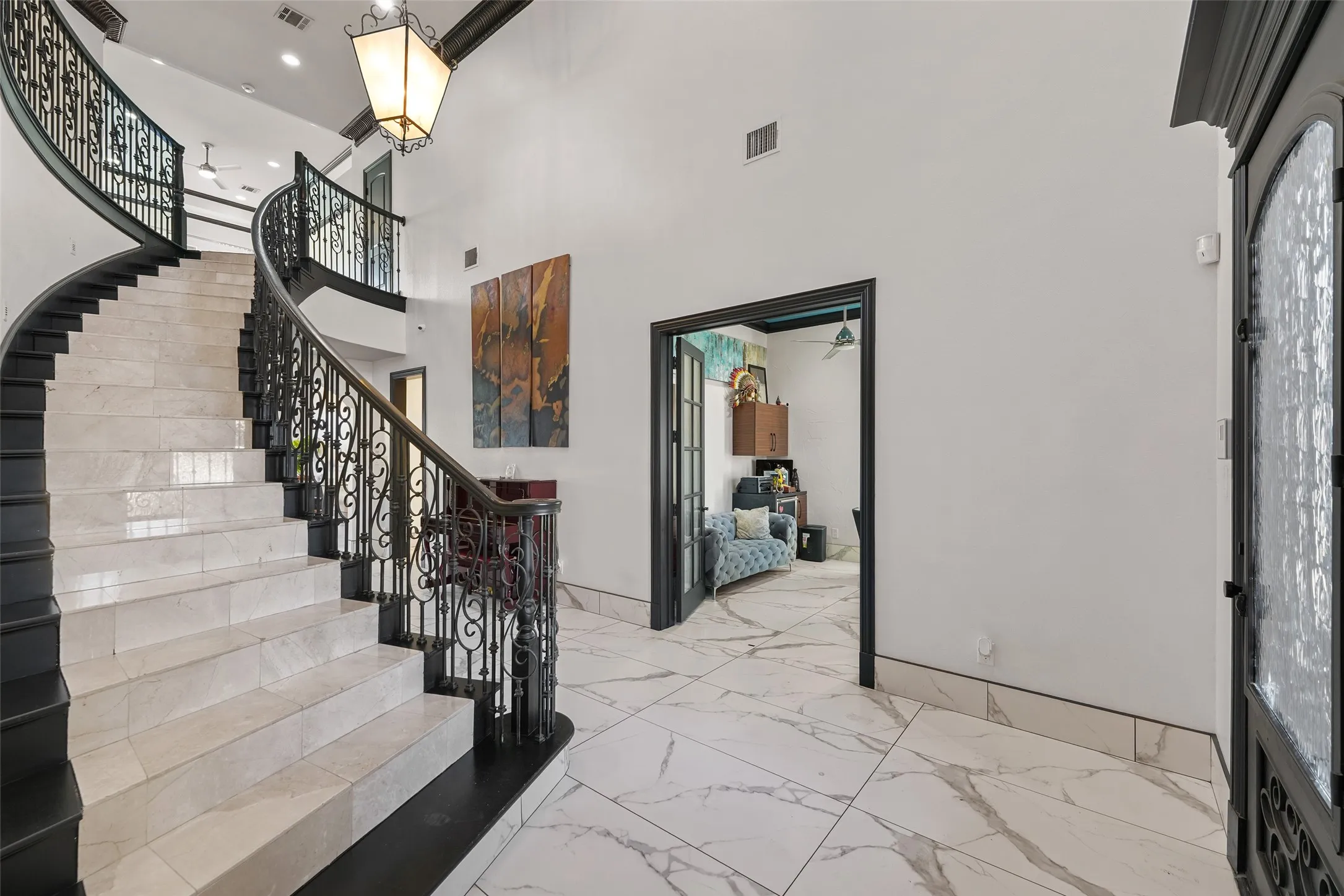 Foyer entrance with light marble finish floors, a high ceiling, and recessed lighting