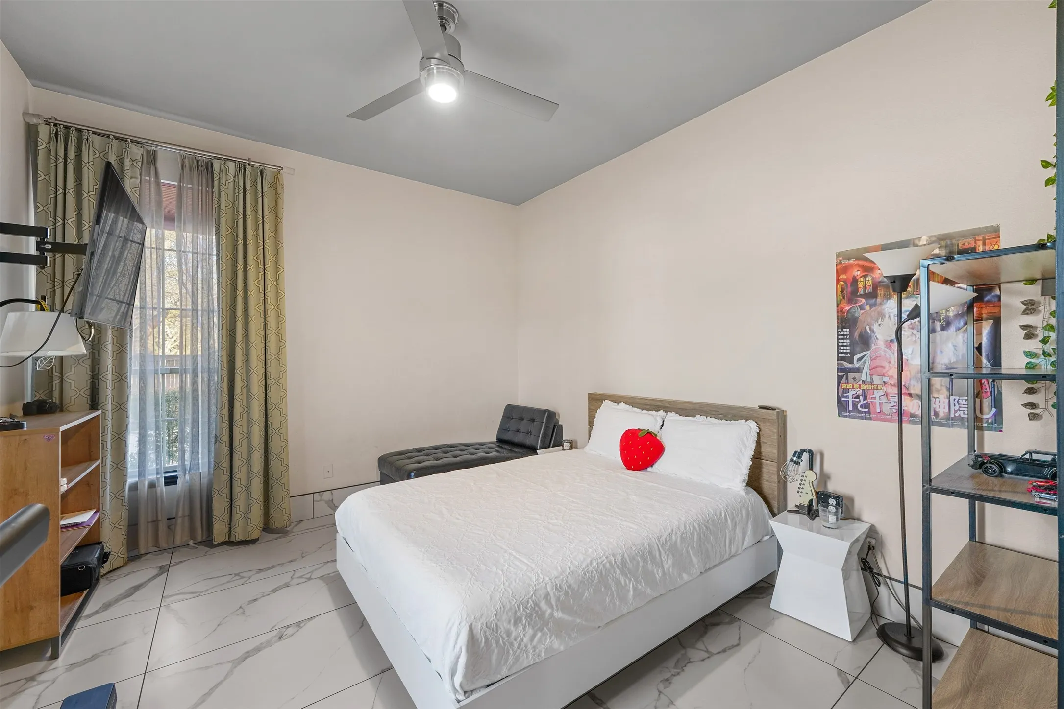 Bedroom with a ceiling fan and light marble finish floors
