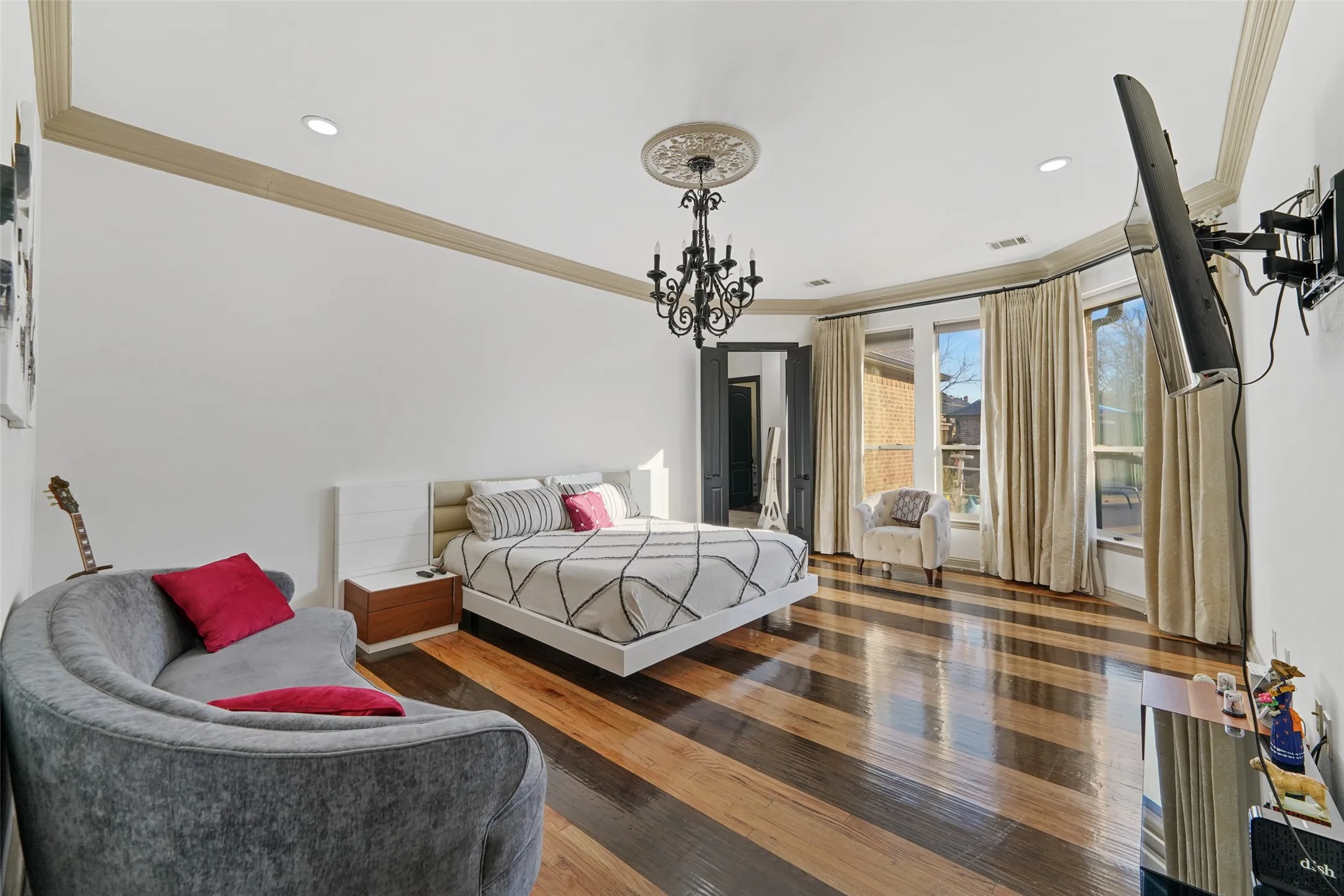 Bedroom with ornamental molding, hardwood / wood-style flooring, and a chandelier
