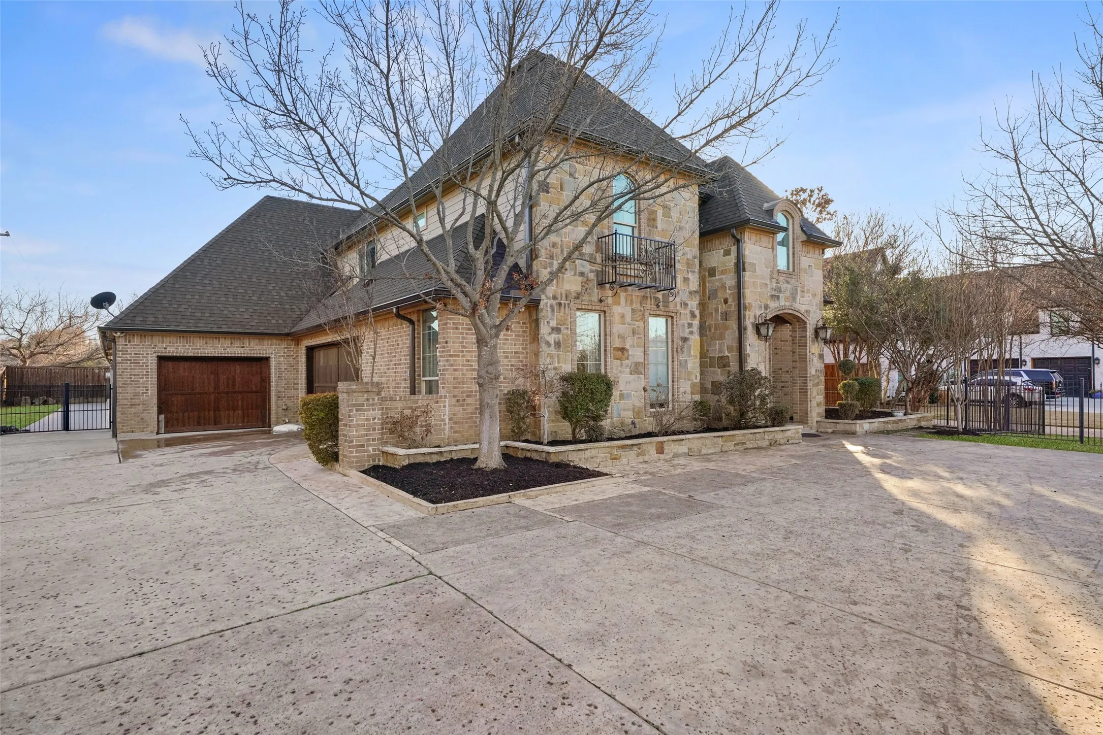 French provincial home with concrete driveway, roof with shingles, brick siding, an attached garage, and stone siding