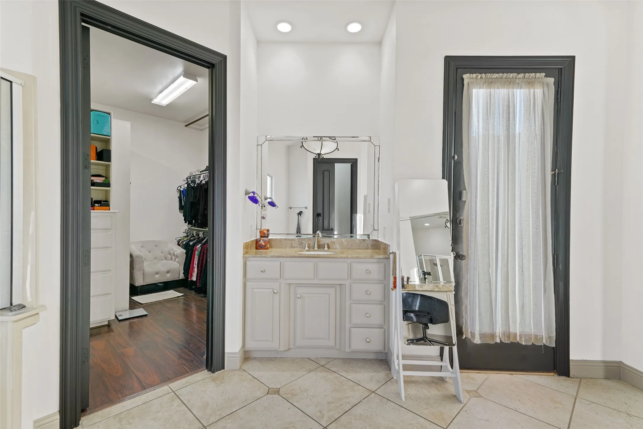 Bathroom with vanity, light tile patterned floors, a spacious closet, and recessed lighting