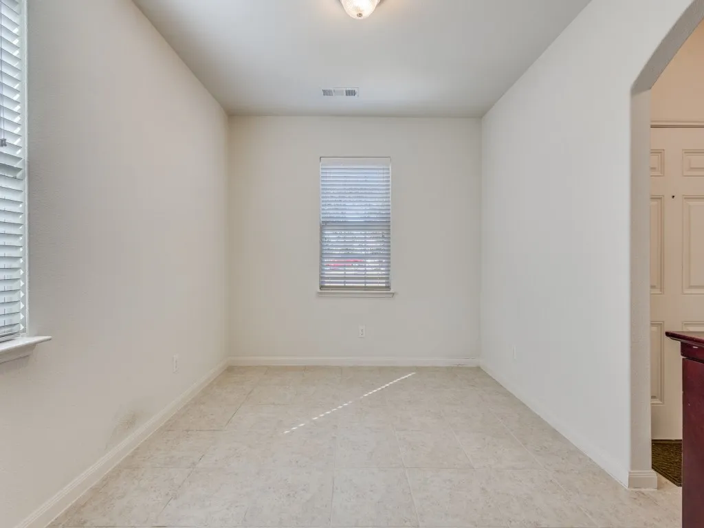 Unfurnished room featuring arched walkways and baseboards