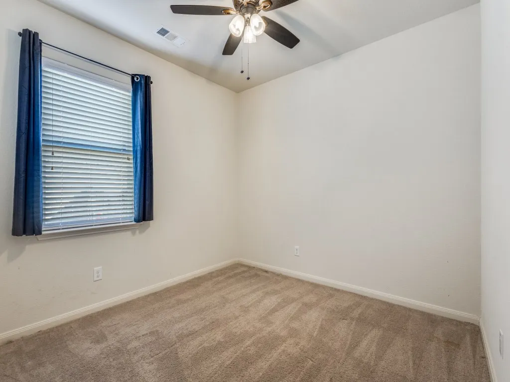Empty room featuring carpet and a ceiling fan