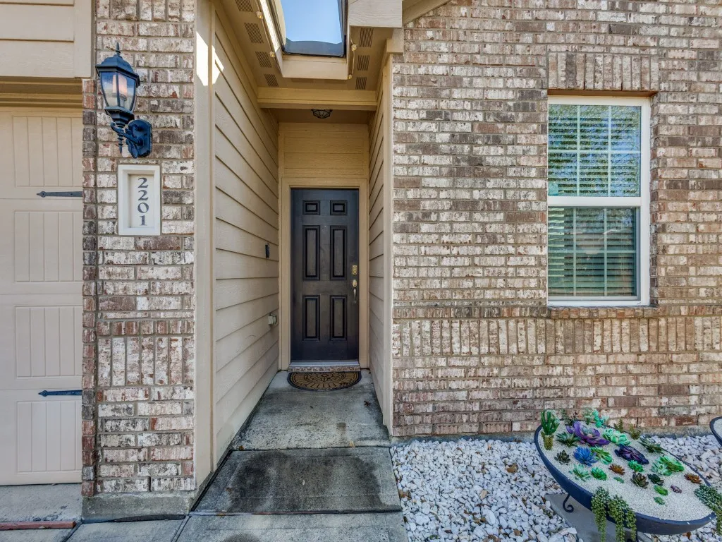 Doorway to property featuring brick siding