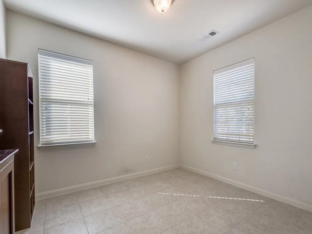 Empty room featuring plenty of natural light and light tile patterned flooring