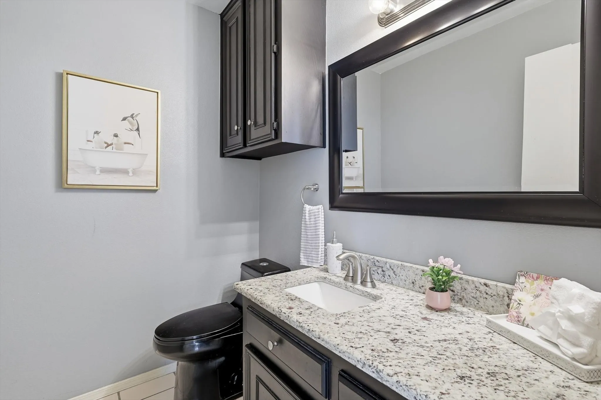 Conveniently located guest half bath with stylish finishes.