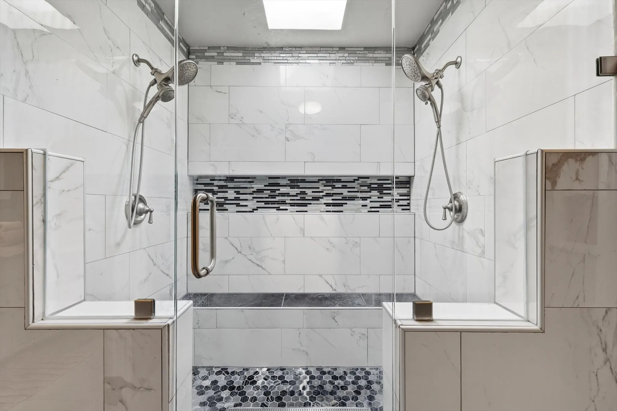 Modern walk-in shower designed for comfort, featuring a built-in seat and a skylight