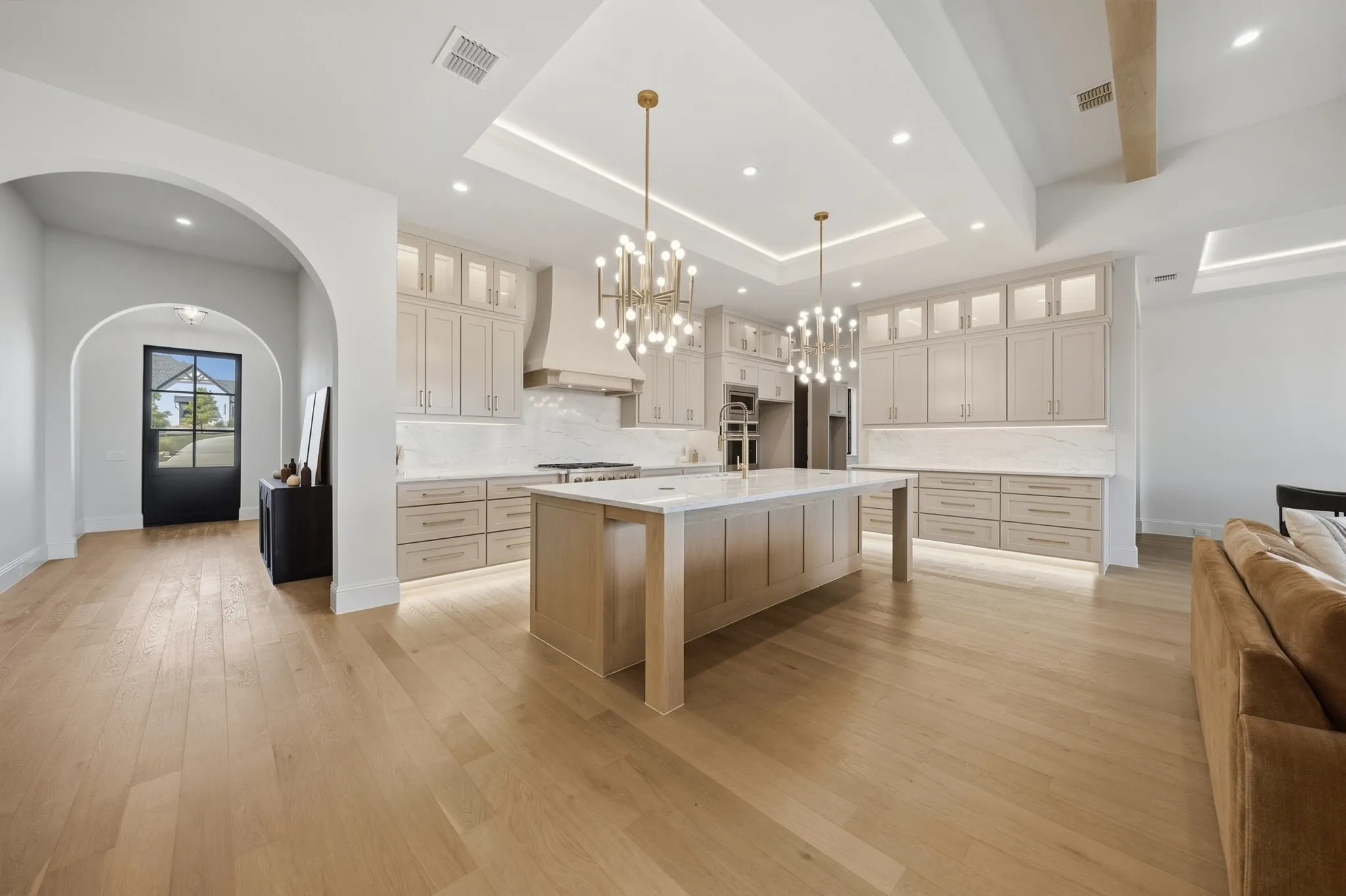 Spacious kitchen featuring an expansive center island, integrated appliances, and extensive cabinetry with under-cabinet lighting