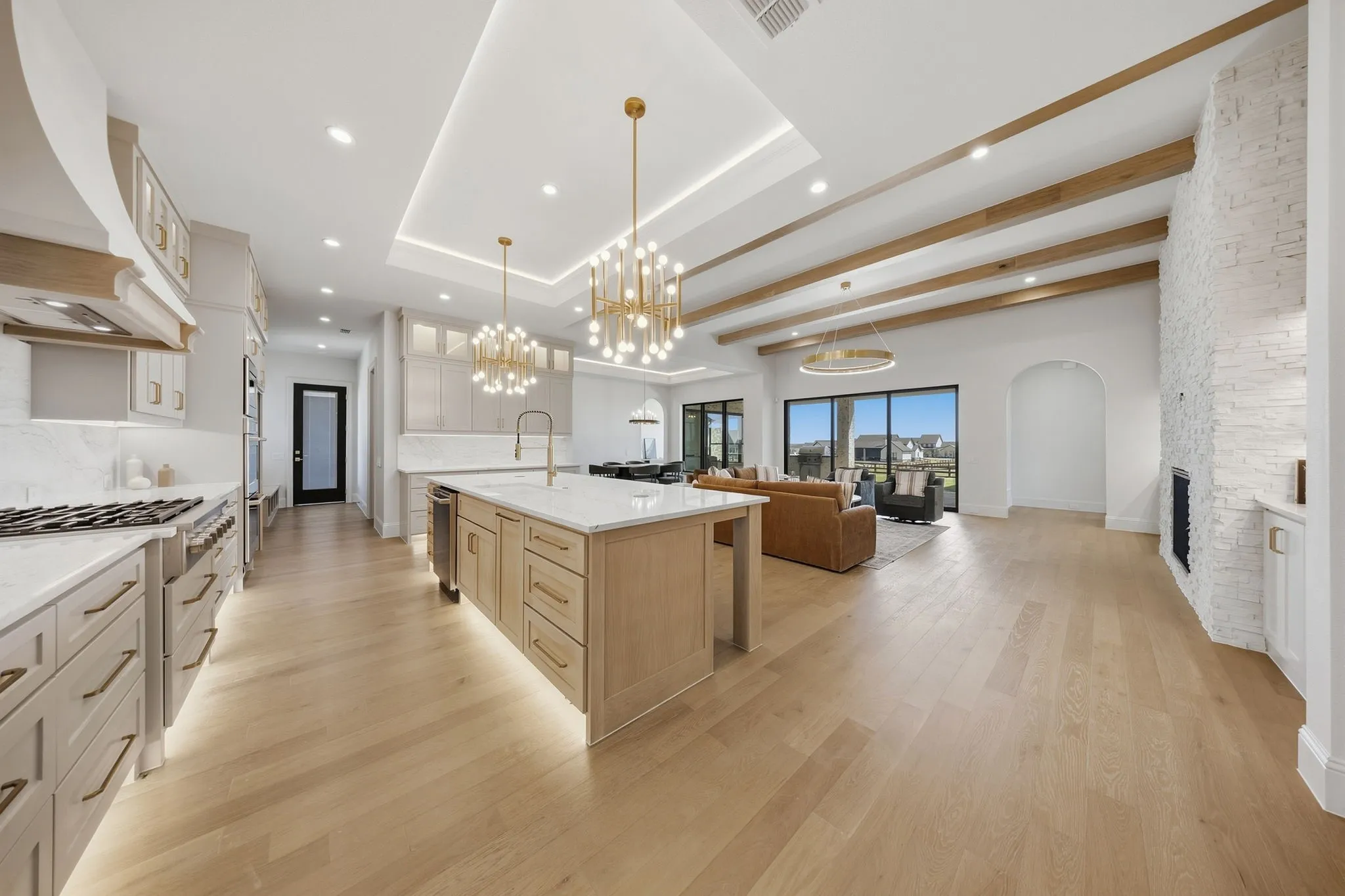 Gourmet kitchen with a large island, stainless steel appliances, and under-cabinet lighting