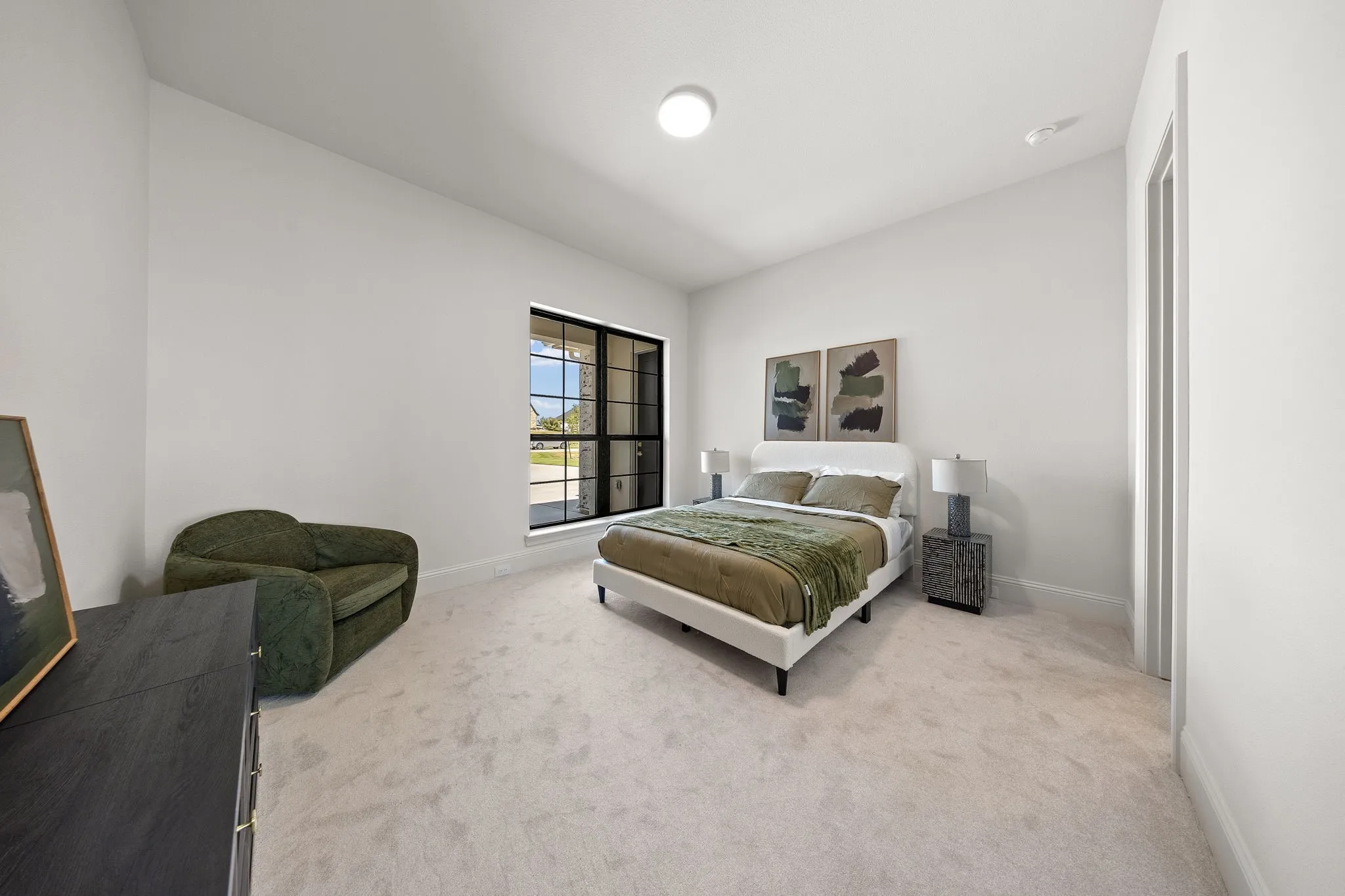 Neutral wall color, carpeted flooring, large window with dark trim, recessed ceiling lighting