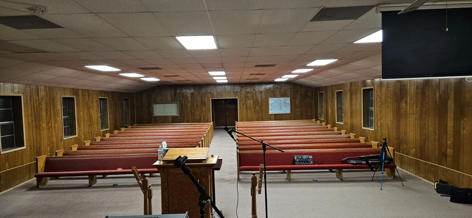 Sanctuary featuring wooden walls, a paneled ceiling, and lofted ceiling