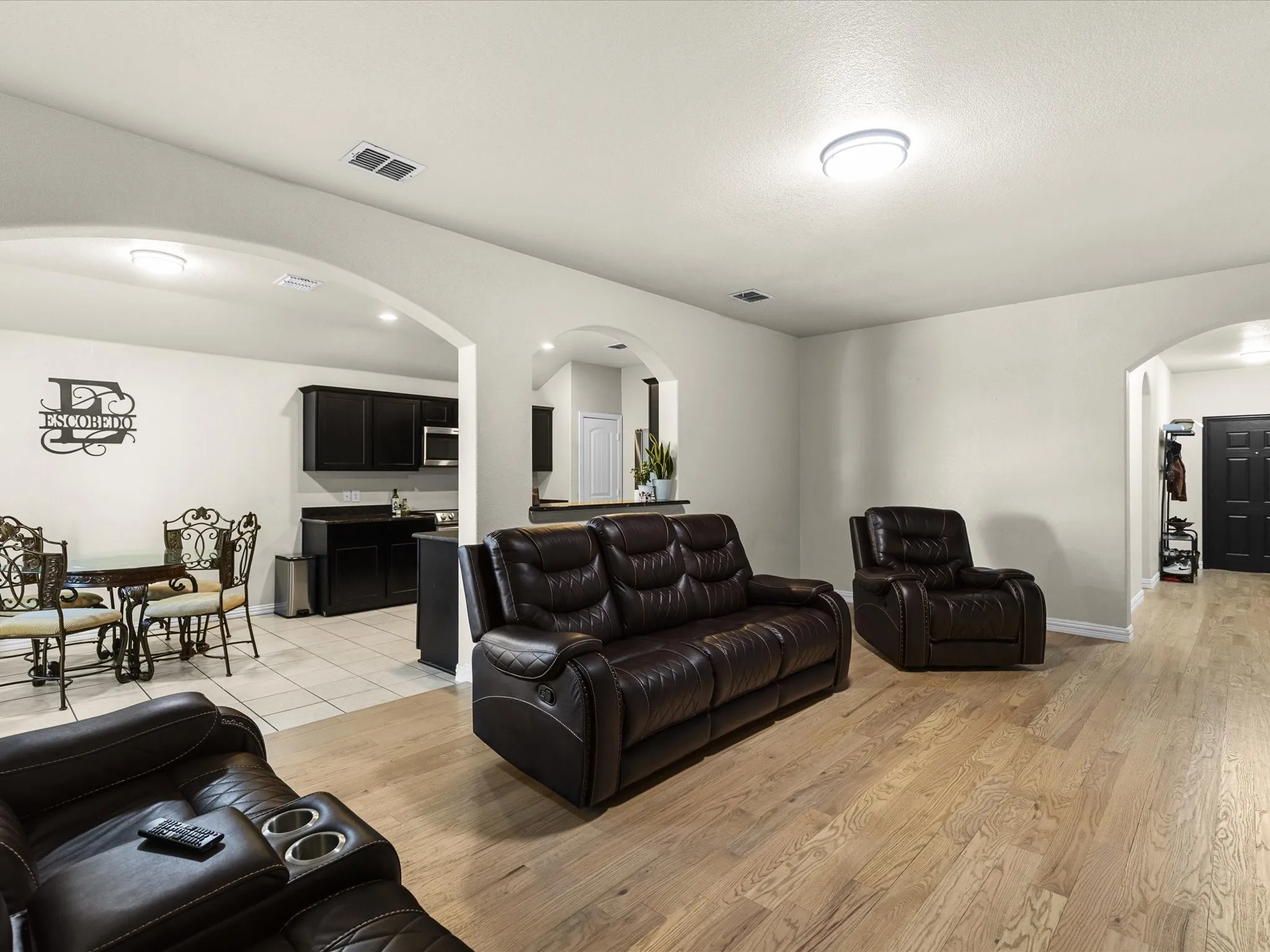 Living room with arched walkways and light wood-style floors