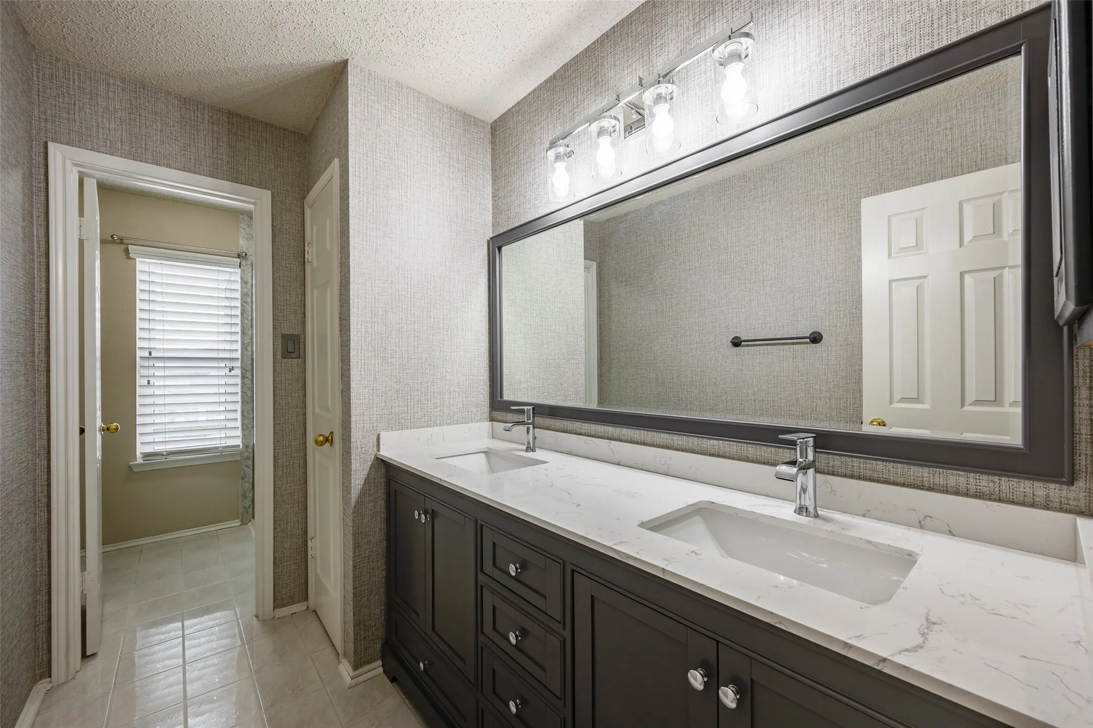 Upstairs Bathroom with dual sinks and shower / tub combo
