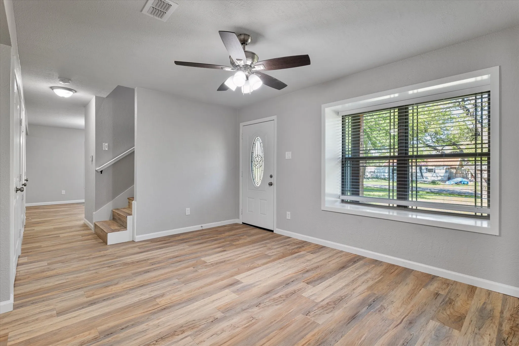 Foyer entrance with ceiling fan and light wood finished floors