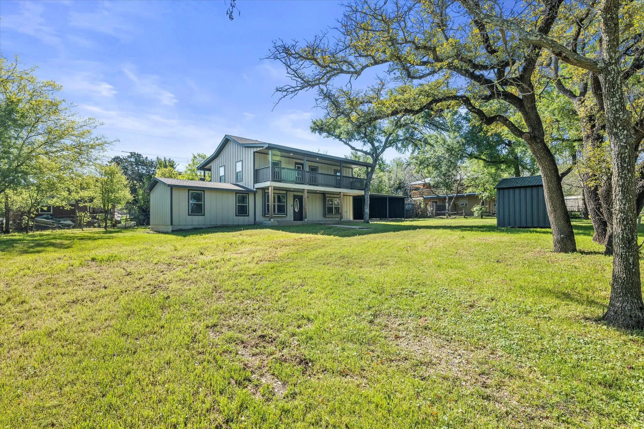 Rear view of property with a lawn, a shed, and a balcony