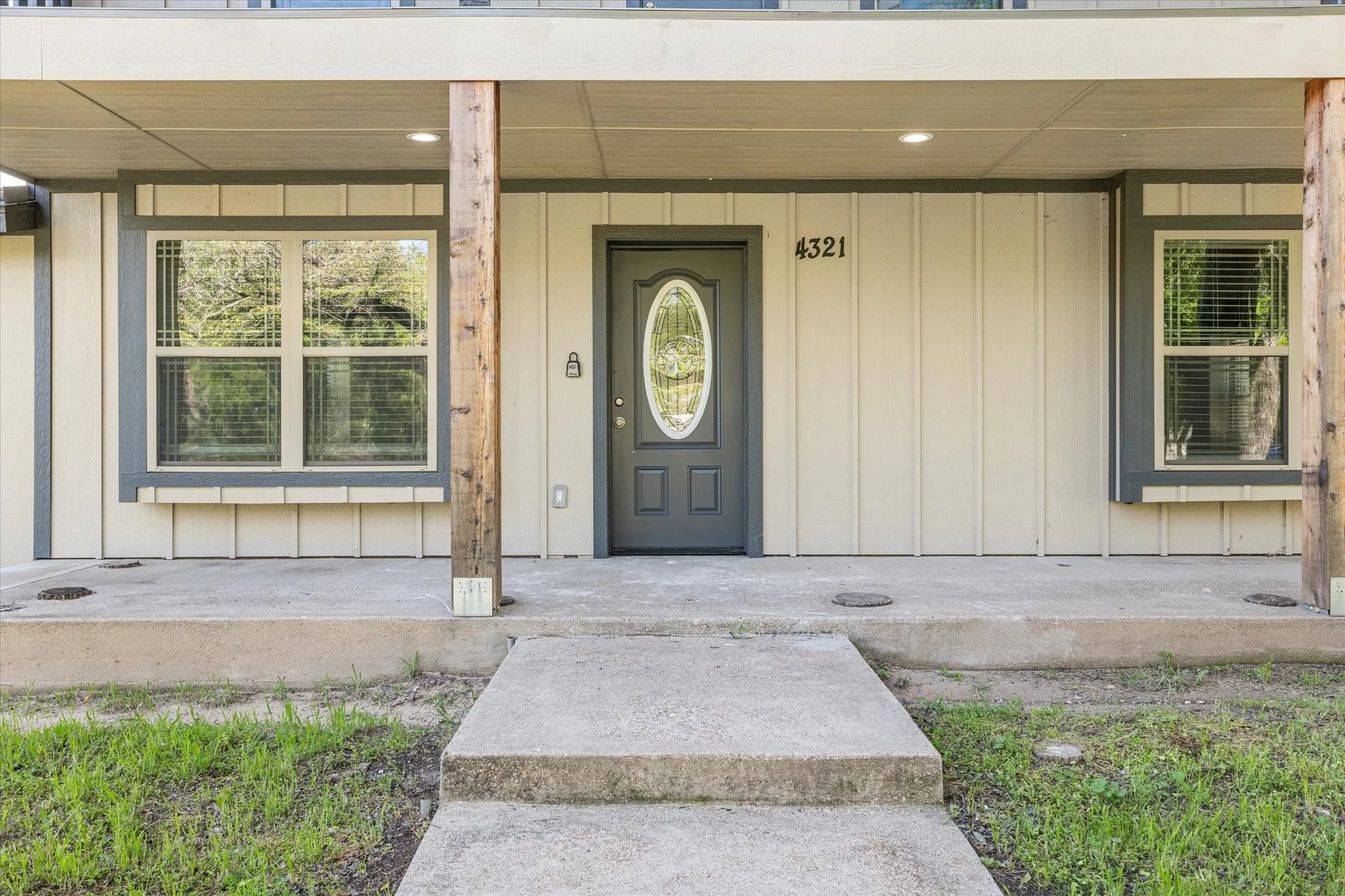 View of exterior entry featuring covered porch and board and batten siding