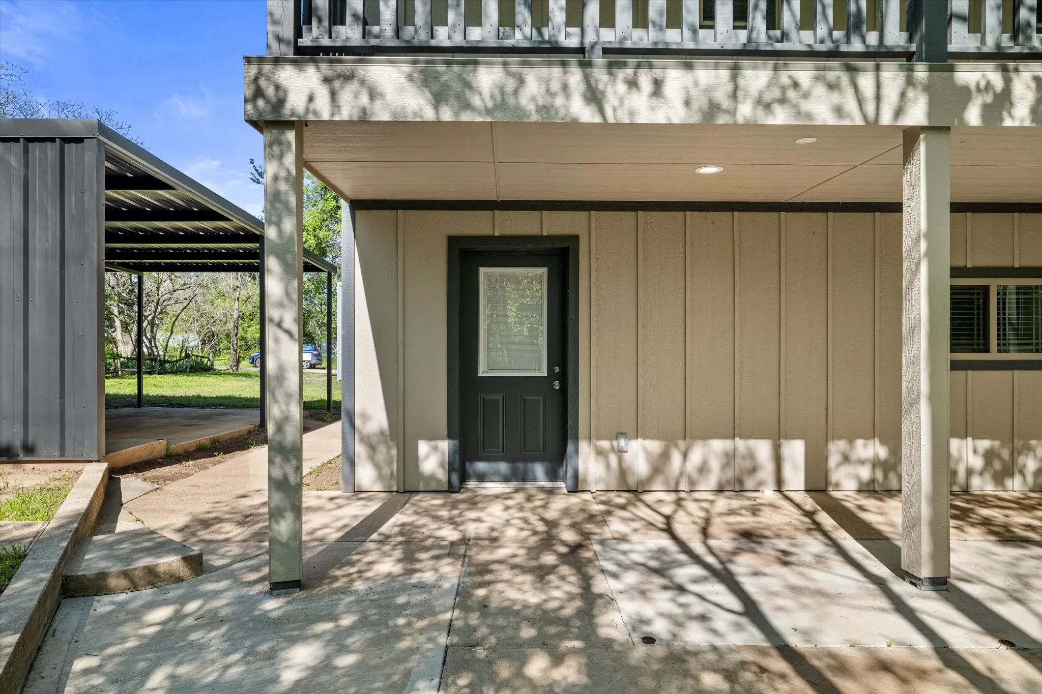 View of exterior entry with a pergola and a patio