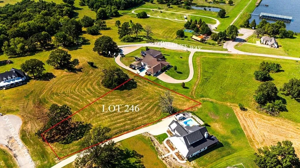 Aerial view of property and surrounding area with property parcel outlined and a nearby body of water