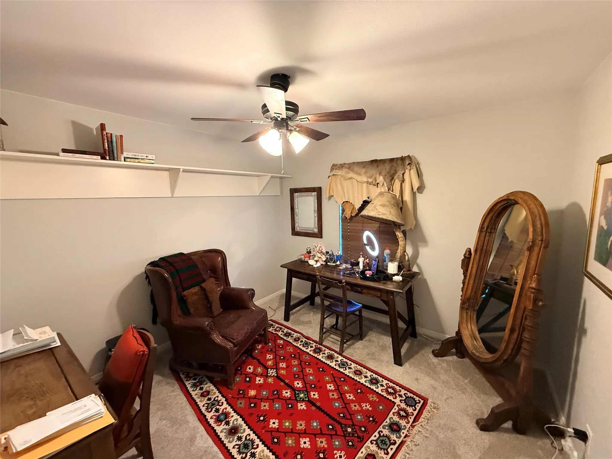 Home office with a ceiling fan and light colored carpet