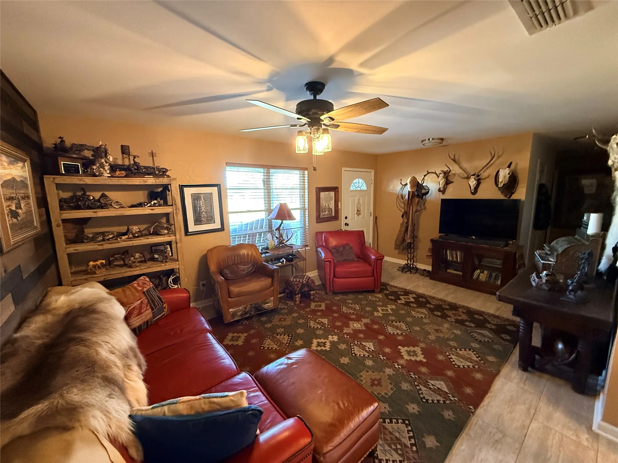 Living area with a ceiling fan and light wood-style flooring