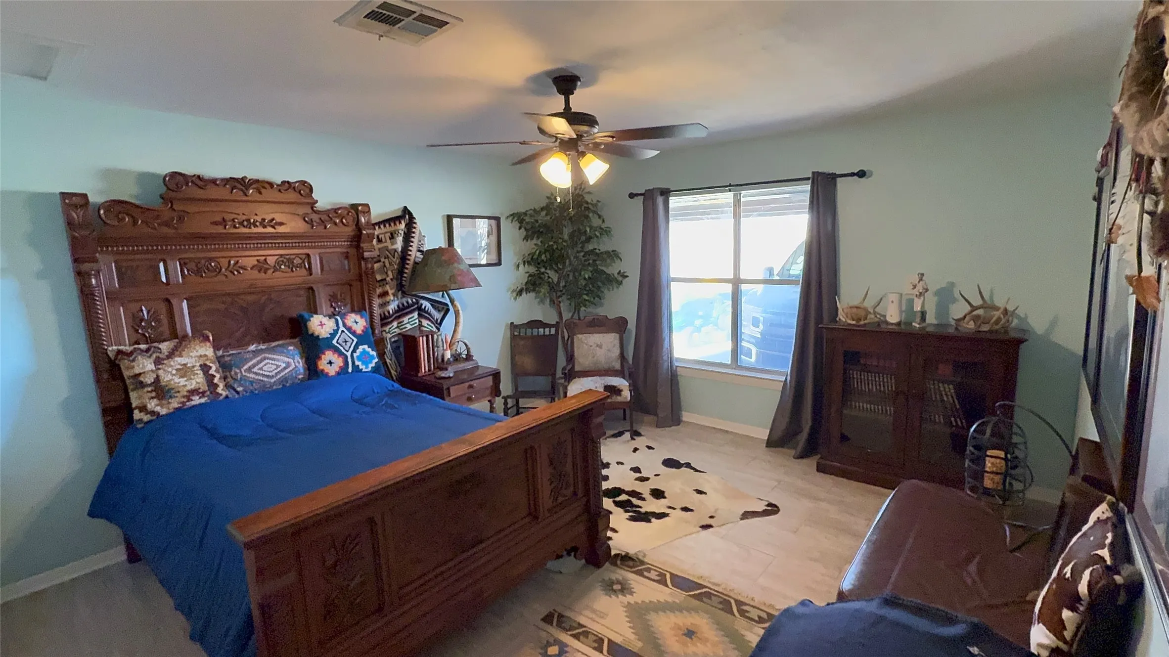 Bedroom with ceiling fan and light wood-style flooring