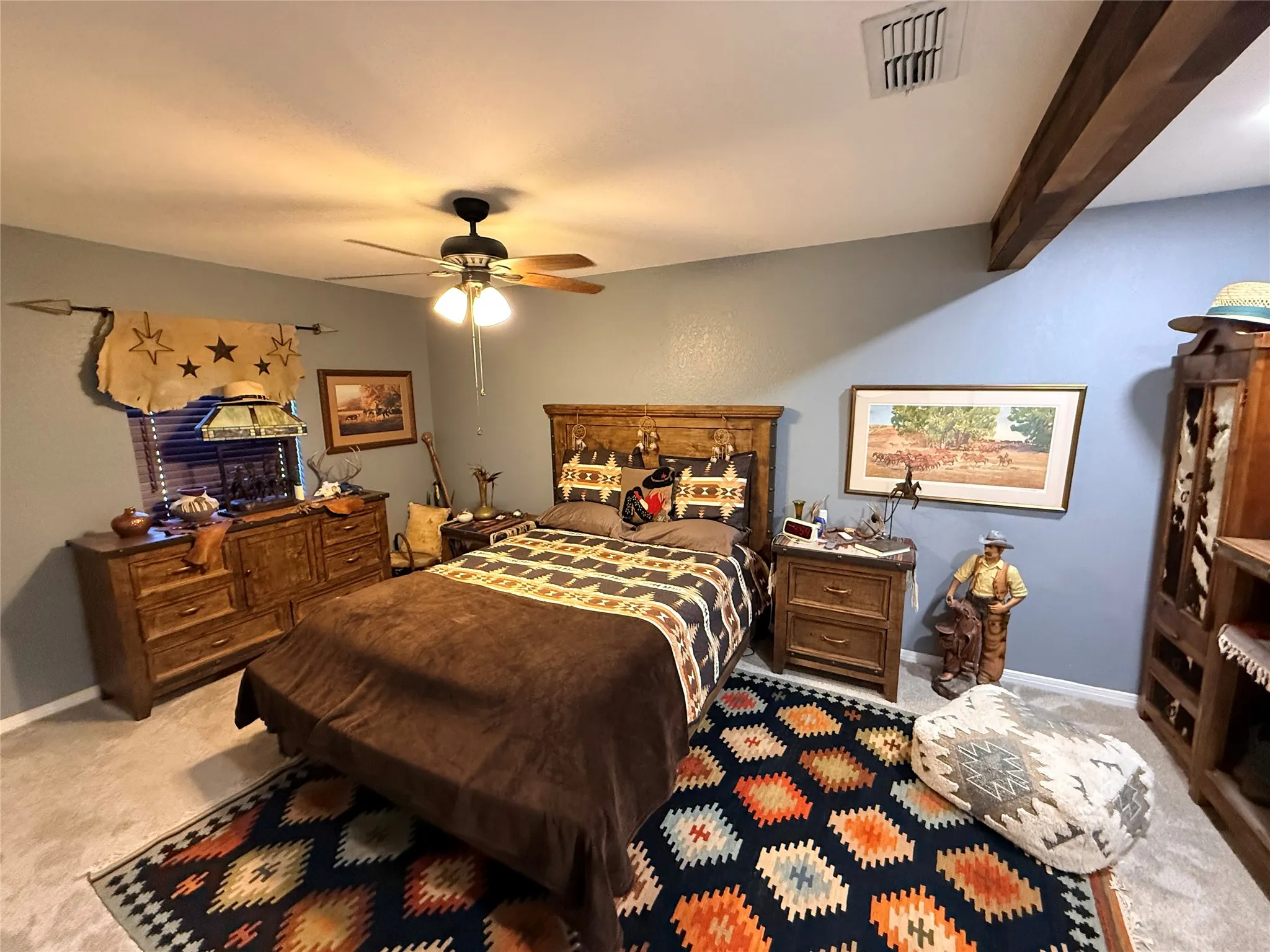 Bedroom featuring light colored carpet, ceiling fan, and beamed ceiling