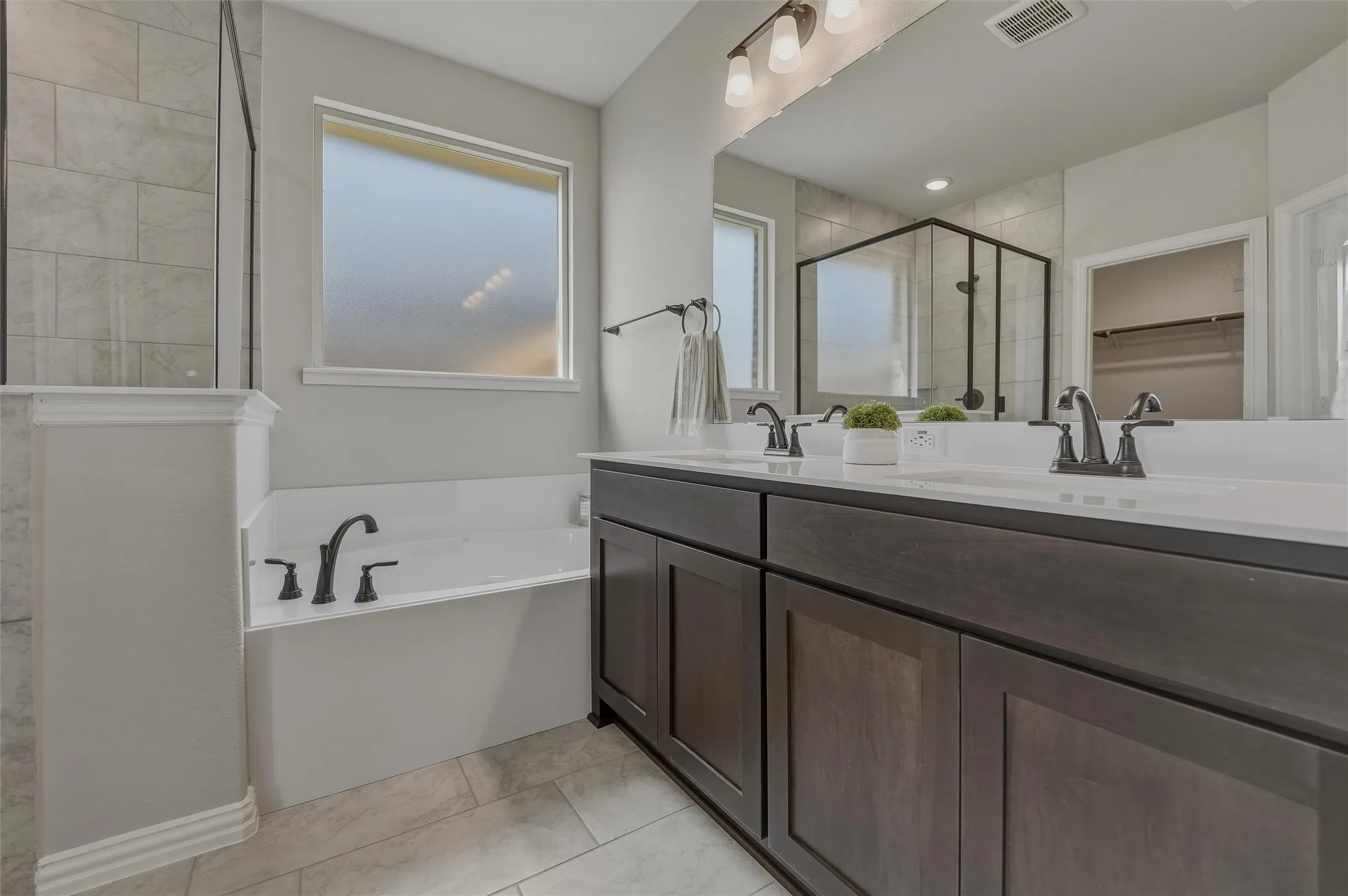 Dual vanity with dark wood-finish cabinetry and white countertops