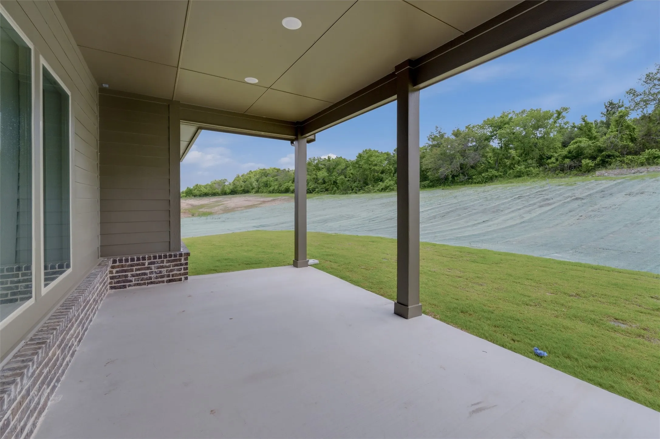 Covered outdoor patio featuring a concrete floor, recessed lighting, and support columns