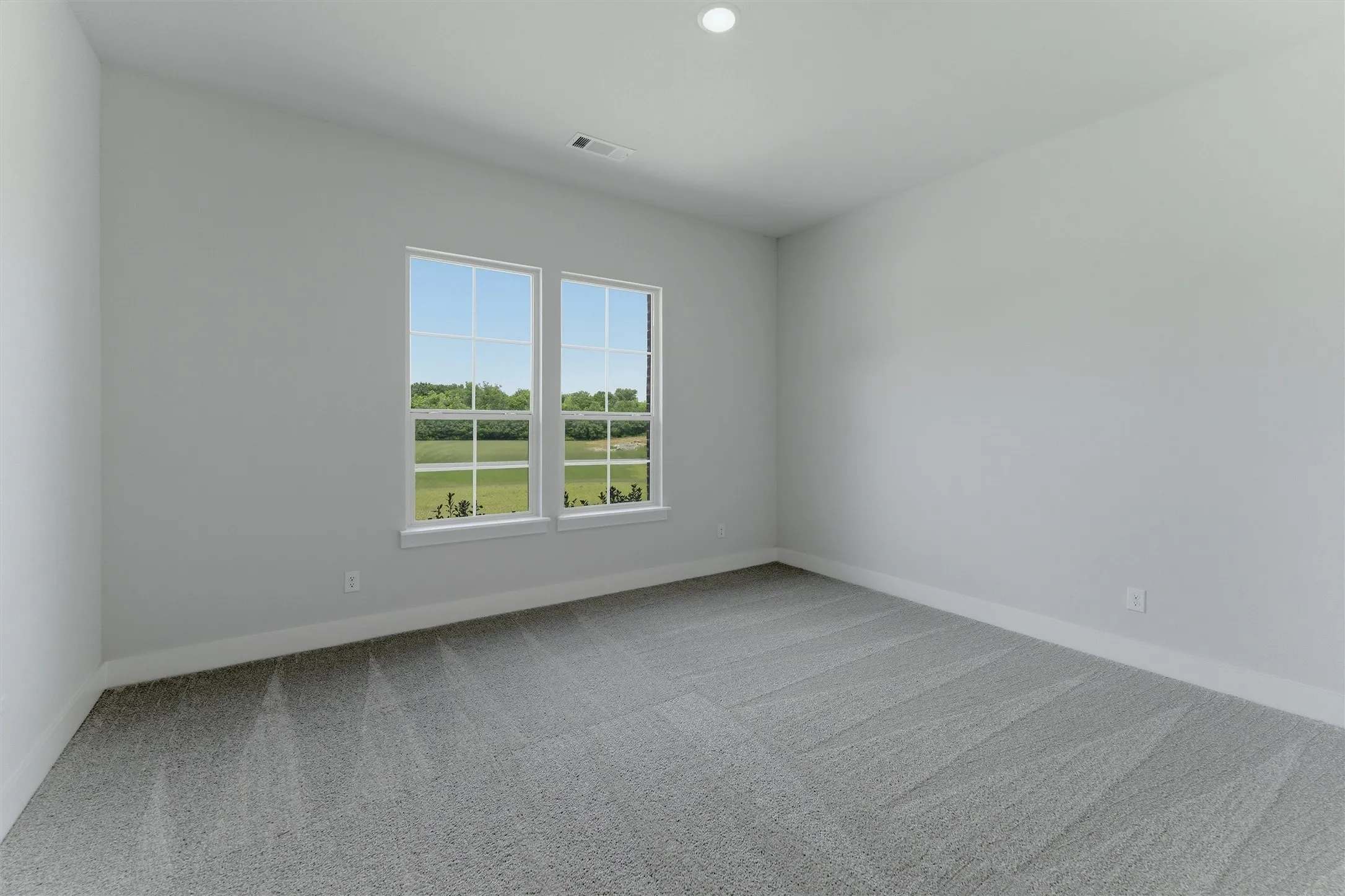 Room featuring dual windows, recessed lighting, neutral wall tones, and gray patterned carpeting
